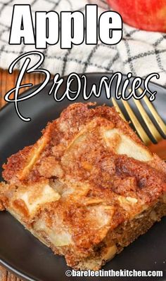 apple brownies on a black plate with a fork and an apple in the background