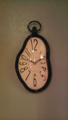 a clock hanging from the wall with numbers on it's face and hour marks