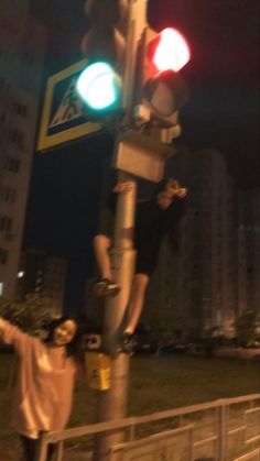 two people standing next to a traffic light