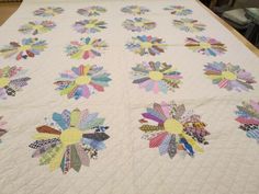 a quilted table topper with colorful flowers on it