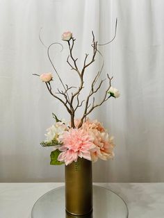 a vase filled with pink flowers on top of a glass table next to a white curtain