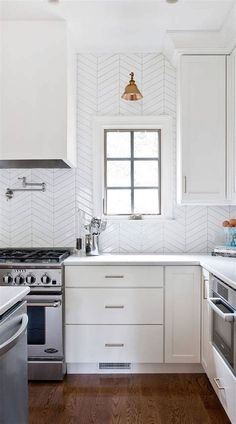 a kitchen with white cabinets and wood floors