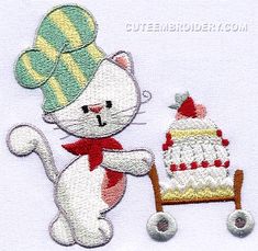 a white cat sitting next to a small cake on a wooden wheelbarrow with a green and yellow hat