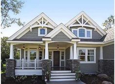 a gray house with white trim and two story front porches on the first floor