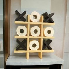 several rolls of toilet paper are stacked on top of each other in a rack with crosses