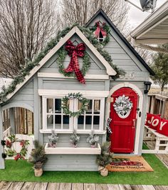 a small house decorated for christmas with wreaths and decorations