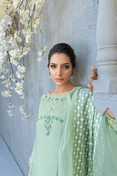 SKU: 2213 Price for Shirt, lining & Pants Ascend into the world of florals in this flowy sage green silk Kalidar ensemble glided with handwork floral details, crystal, pearls, and sequence paired with an organza dupatta with lavished laces. The border tucked with resham embroidery and florals gives this ensemble a classic look. Dupatta as is can be added. Green Chanderi Lawn Suit With Mirror Work, Elegant Green Lawn Suit With Mirror Work, Green Chikankari Embroidered Lawn Suit, Green Chikankari Embroidered Lawn Suit In Chinon, Pista Green Georgette Palazzo Set With Dabka, Green Silk Unstitched Suit With Mirror Work, Green Chinon Sets With Mirror Work, Green Dola Silk Palazzo Set With Mirror Work, Green Silk Salwar Kameez With Mirror Work