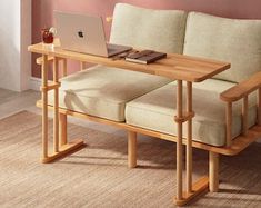 a laptop computer sitting on top of a wooden table next to a couch in a living room