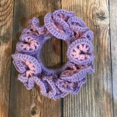 a purple crocheted scrunffle on a wooden surface