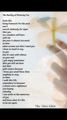 a person's hand holding a flower in front of a poem