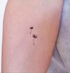 a single dandelion tattoo on the left arm