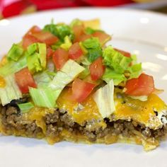 a slice of taco casserole with lettuce and tomatoes on top