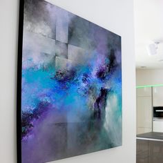 an abstract painting hanging on the wall in a kitchen