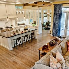 a kitchen and living room are shown in this open concept house plan, which includes an island with seating for four