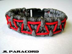 a close up of a bracelet with red and gray braiding on the inside of it