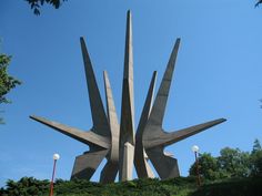 a large metal sculpture sitting on top of a lush green field