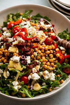 an image of a salad with chickpea and feta cheese on top in a white bowl