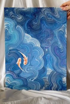 two koi fish are swimming in the water with blue swirls on it's surface