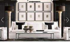 a living room filled with white furniture and pictures on the wall above it's coffee table