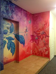 an empty room with painted flowers and leaves on the walls