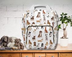 a backpack with dogs all over it sitting on top of a dresser next to a potted plant