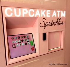 a pink cupcake atm machine with buttons on the front and side panels that read cupcake atm sprinkles