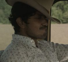 a man wearing a cowboy hat sitting in a car