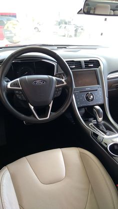 the interior of a car with leather seats and steering wheel, dash board and dashboard