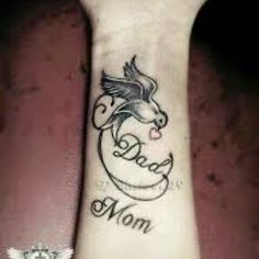 a woman's wrist tattoo with the word mom on it and a bird flying above her arm