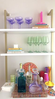 the shelves are filled with bottles, glasses and other decorative items on it's sides