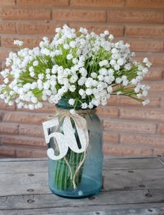 a vase filled with white flowers on top of a wooden table