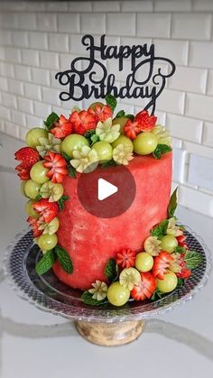 a watermelon birthday cake with grapes and strawberries