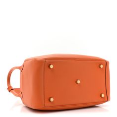 This is an authentic HERMES Taurillon Clemence Lindy 26 in Orange. This chic tote is crafted of luxurious taurillion clemence calfskin leather in orange. This stylish shoulder bag features front ward facing rolled leather top handles on either side with a cross-over top flap and a silver plated turn lock closure. This opens to a matching leather interior with side patch pockets. Lindy 26, Stylish Shoulder Bag, Leather Interior, Leather Top, Patch Pocket, Calf Skin, Silver Plated, Handles, Shoulder Bag