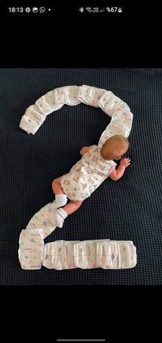 a baby laying on top of a black mat