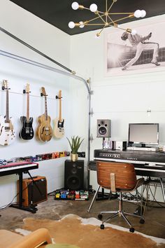 a room with guitars hanging on the wall and other musical equipment in front of it