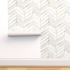 a white and gold herringbone wallpaper in an empty room