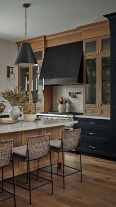 a large kitchen with wooden cabinets and white counter tops is pictured in this image, there are four chairs at the center of the island