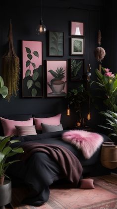 a bedroom with black walls, pink and green decor and pictures on the wall above it