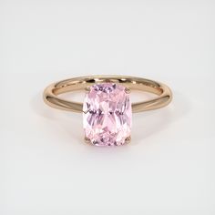 a ring with a pink diamond in it on a white surface and the band is gold