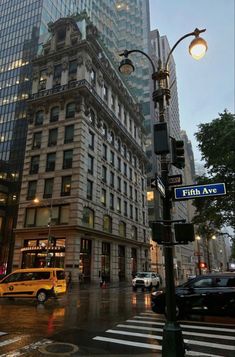 an intersection in the city at dusk with cars and people walking on the street near tall buildings