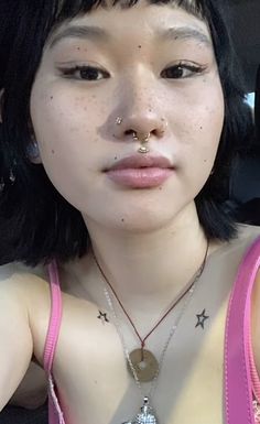 a woman with piercings on her nose and chest