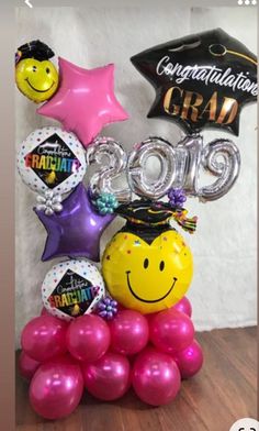 balloons and heliums are arranged in the shape of a graduate's cap, star, and graduation cap