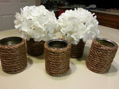 four vases with flowers in them sitting on a table