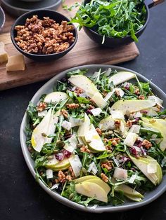 a salad with apples, walnuts and cranberries in a bowl on a table