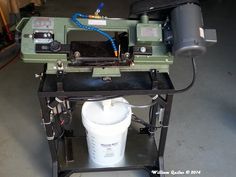 a machine that is sitting on top of a table with a bucket in front of it