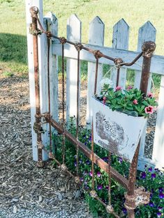 a white picket fence with flowers growing in it