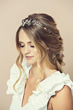 a woman with long hair wearing a white dress and a tiara on her head