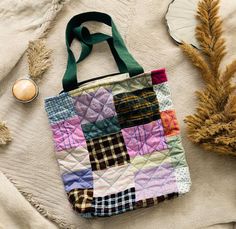 a multicolored bag sitting on top of a table next to some dried plants