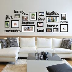 a living room filled with white furniture and pictures on the wall above it's coffee table