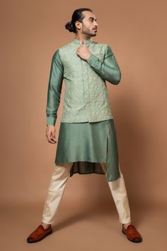 Olive green bundi with all over floral embroidery. Paired with matching draped kurta and pant. - Aza Fashions Traditional Cotton Silk Nehru Jacket For Festivals, Green Cotton Sherwani For Navratri, Green Cotton Nehru Jacket For Diwali, Fitted Pista Green Nehru Jacket For Diwali, Cotton Nehru Jacket With Traditional Drape For Eid, Cotton Nehru Jacket For Eid With Traditional Drape, Eid Nehru Jacket With Traditional Drape In Cotton, Eid Nehru Jacket In Cotton With Traditional Drape, Bollywood Style Fitted Nehru Jacket In Cotton Silk